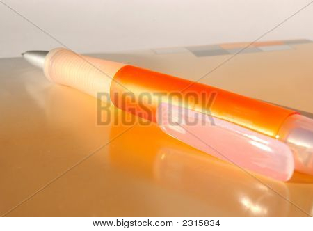 Cuaderno y pluma naranja