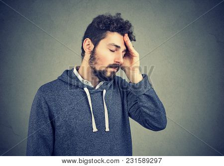 Young Casual Hipster With Beard Suffering From Misfortune Looking Tired While Rubbing Head.