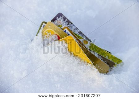 Frozen Bank Account Concept Photo. Credit Cards Buried In Snow.