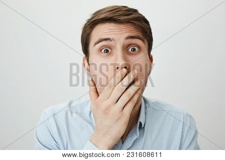 I Am Shocked To Bottom Of My Heart. Portrait Of Terrified And Amazed European Male Model Covering Mo