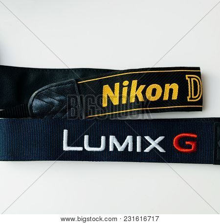 Paris, France - Jan 14, 2015: Nikon Dslr And Panasonic G Mirrorless Camera Straps On White Backgroun