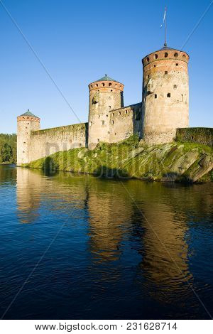 Towers Of The Olavinlinna Fortress In The Rays Of The Setting Sun In The August Evening. Savonlinna,