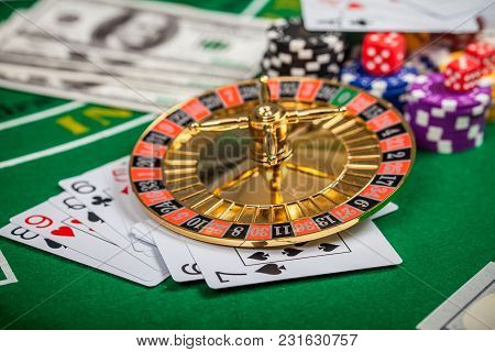 Casino Roulette. Poker Chips On Table In Casino. Cards On Green Felt Casino Table