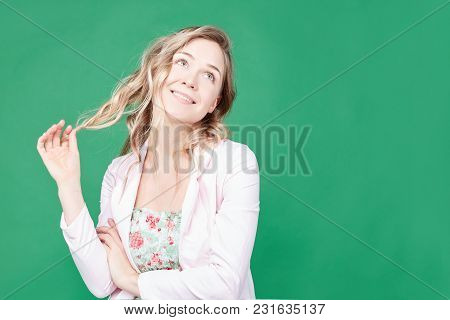 Cute Playful Young Woman With Beautiful Eyes And Charming Mysterious Smile, Touching Her Blond Wavy 