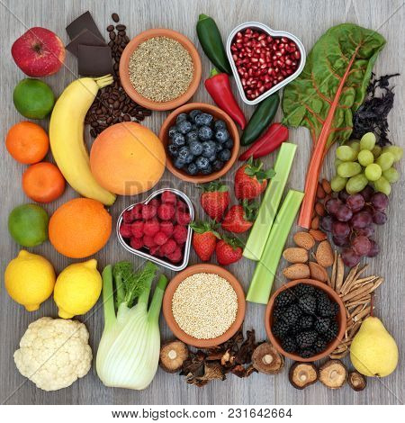 Diet health food concept with fresh fruit, vegetables, coffee, grains, nuts, chocolate, ginseng and tribulus terrestris herbal medicine used as an appetite suppressant and aphrodisiac. Top view.