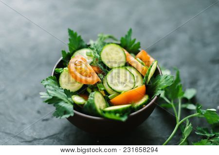 Fresh Salad With Vegetables On A Black Matte Background. The Concept Of A Healthy Diet.