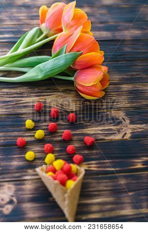 Blossoming Red Tulips On A Wooden Background With Sweets