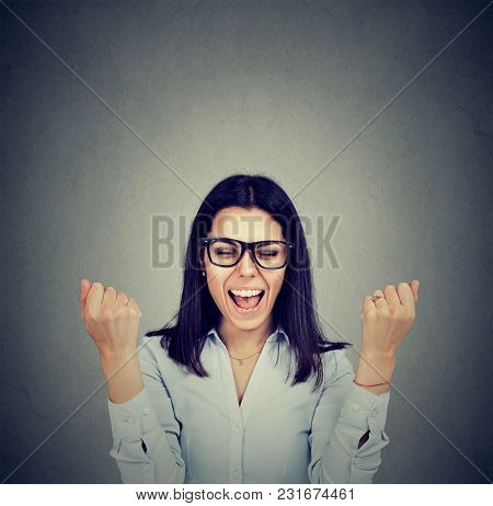 Happy Woman Exults Pumping Fists Celebrates Success On Gray Wall Background