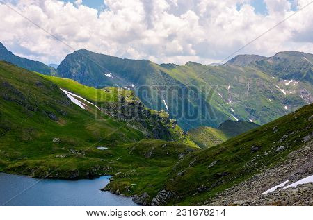 Lake Capra In Fagarasan Mountains Of Romania. Beautiful Summer Scenery On A Cloudy Day. Popular Tour