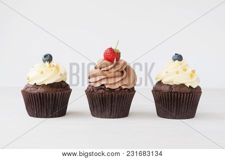 Cupcakes With Whipped Chocolate And Vanila Cream, Decorated Fresh Strawberry, Blueberry, Gold Confec
