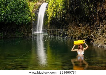 Young Woman Walking Through Lagoon With A Dry Bag At Wainibau Waterfall On Taveuni Island, Fiji. Tav