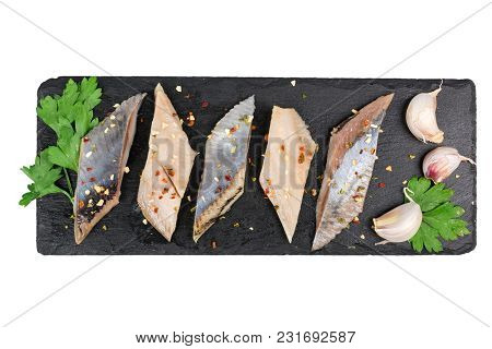 Herring Fillet With Lsalt, Pepper And Herbs On Black Slate Isolated On White Background. Top View