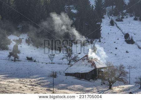 Idyllic Rural Winter Scenery With An Old Wooden House In Fundata Village, Brasov County, Romania.