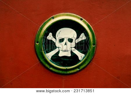 Skull And Crossbones On A Ships Porthole With A Red Background