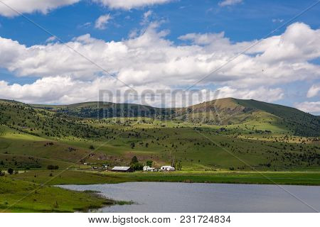 Nestled In A Valley, An Eastern Oregon Farm Operates Next To A Small Lake.