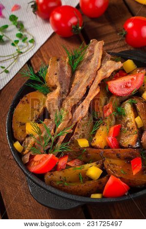 Fried Potatoes With Bacon And Fresh Tomatoes In The Frying Pan. Wooden Rustic Background. Top View.