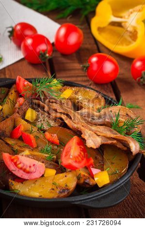 Fried Potatoes With Bacon And Fresh Tomatoes In The Frying Pan. Wooden Rustic Background. Top View.