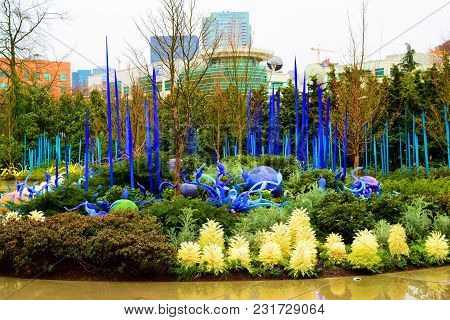 March 8, 2018 In Seattle, Wa:  Plants And Flowers Amongst Glass Art Sculptures With The Seattle Skyl