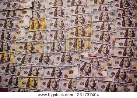 Hundreds Of New Benjamin Franklin 100 Dollar Bills Arranged Randomly With The Portrait Facing Upperm
