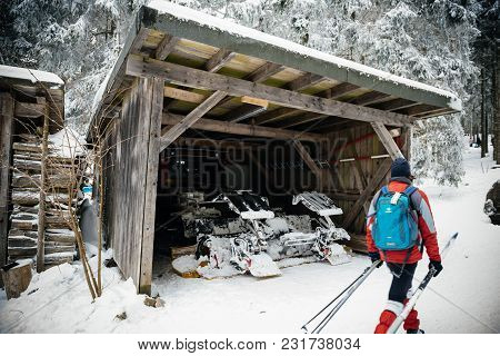 Mummelsee, Germany - Feb 18, 2018: Skier Near The Garage Of The Modern Snow Plough Groomer In Mummel