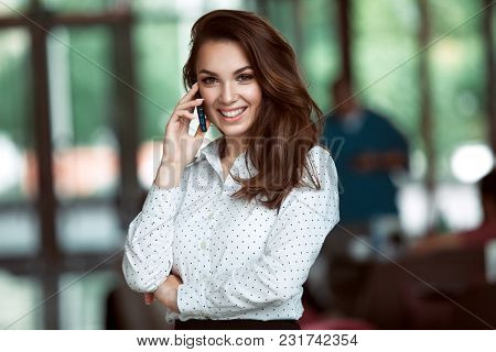 Smiling Businesswoman Talking On The Phone At The Office