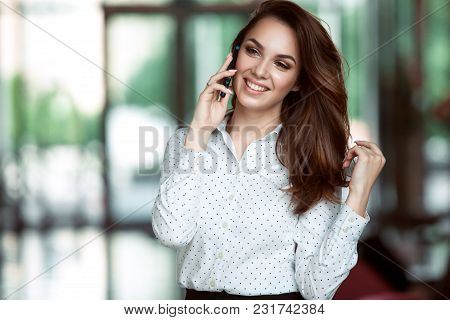 Smiling Businesswoman Talking On The Phone At The Office