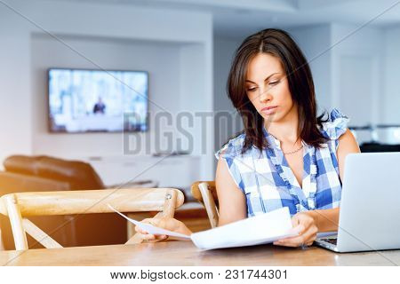 Woman with papers in their living room
