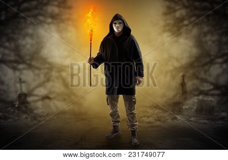 Man with burning flambeau coming from thicket and looking something