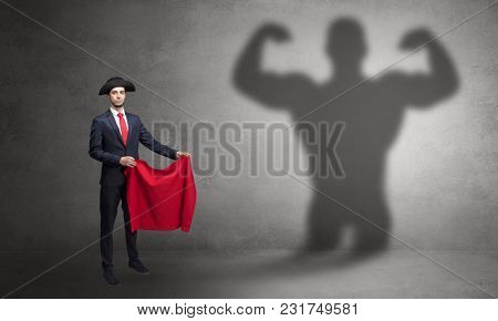 Businessman standing with red cloth on his hand and strong hero shadow on the background