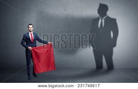 Businessman standing with red cloth on his hand and his shadow on the background