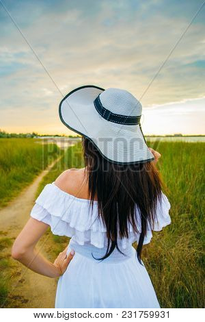 Woman In A White Dress On An Asshole In A Green Field