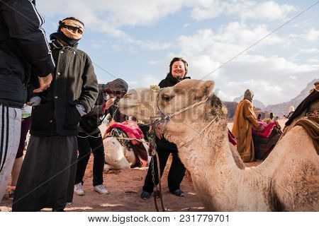 Wadi Rum, Jordan - December, 25, 2017: Tourists And Bedouins Near Camals In Wadi Rum Desert In Jorda