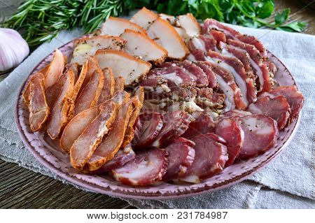 Big Meat Set. Homemade Smoked Pork-beef Sausage, Salted Bacon, Basturma Chopped Slices On A Wooden B