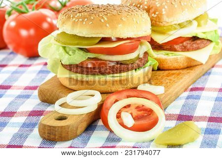 Concept Image Of Traditional Homemade Hamburgers With Beef, Lettuce, Cheese, Tomato And Pickles On W