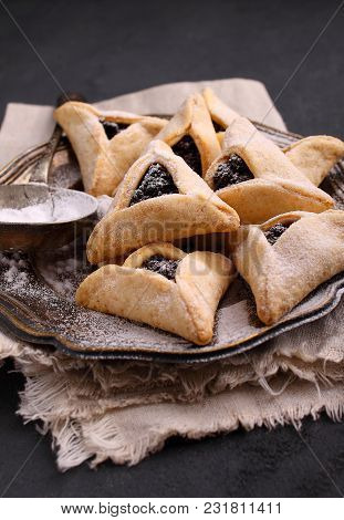 Hamantaschen Cookies With Poppy Seed And Risins And Icing Sugar On A Plate, Cooked For Jewish Festiv