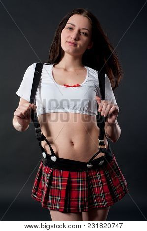 Young Pretty Woman In White Top And Red Mini Skirt Over Black Background