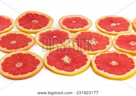 Round Slices Of The Ripe Red Grapefruits With Peel On A White Background At Shallow Depth Of Field