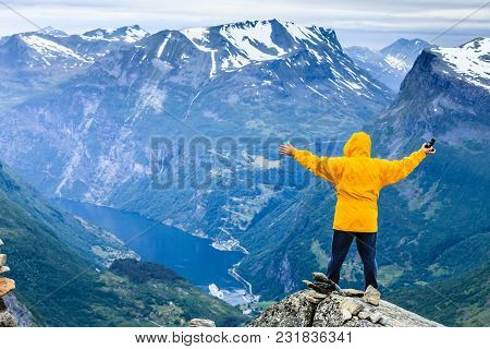 Tourism Vacation And Travel. Happy Free Tourist Man With Arms Raised Outstretched Up Looking At Geir