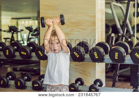 A Boy Lifts Up To, A Dumbbell In The Gym.
