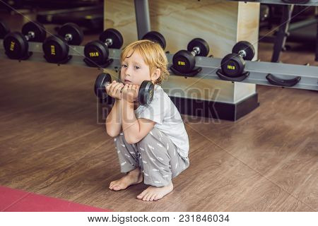 A Boy Lifts Up To, A Dumbbell In The Gym.