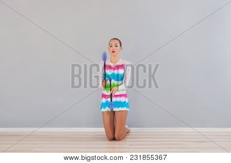 Rhythmic Gymnastic Girl Using Mace Clubs In The Gym
