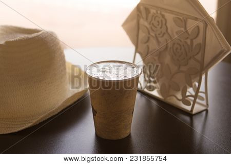 A Cup Of Coffee On A Table In A Cafe With A White Hat And White Napkins