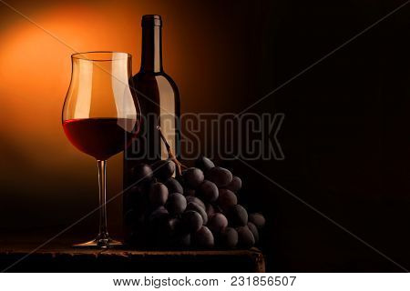 Goblet Of Red Wine With Bottle And Bunch Of Grapes