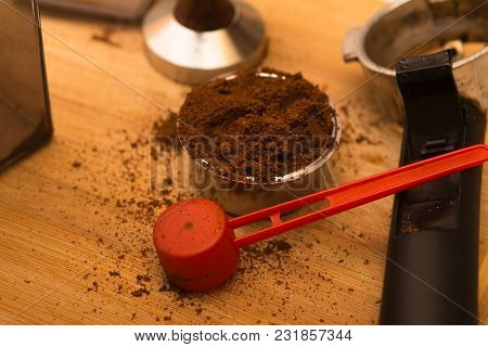 Coffee Tamper With Coffee In Filter Basket And Filter Holder On A Wooden Board For Coffee Scrub