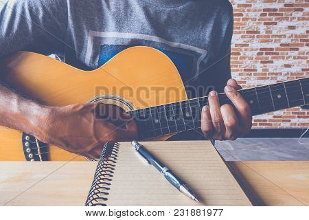 Man Composing A Song And Play Guitar With Paper
