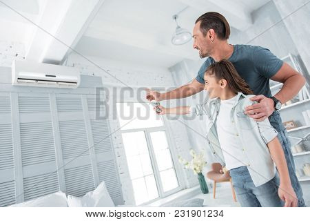 Comfortable Temperature. Positive Happy Joyful Man Standing Near His Daughter And Pointing At The Ai
