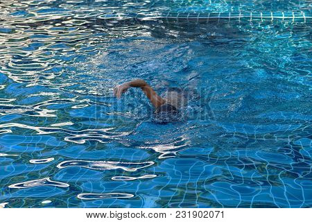 Little Boy Swims In Pool. Front Crawl Swimming Stroke
