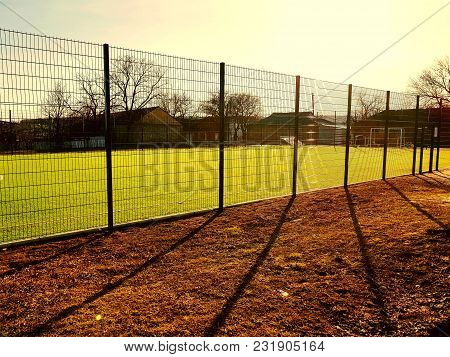 Lawn Field For Playing Minifootball Behind The Green Fence Mesh