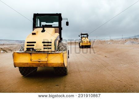 Two Vibratory Soil Compactors On Construction Site. Industrial Roadworks At Highway With Heavy-duty 