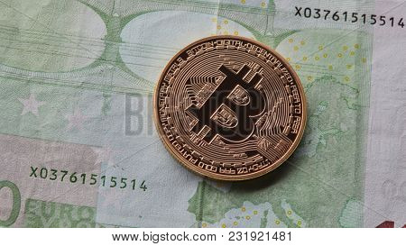 One gold coin of bitcoin on the background of euro.